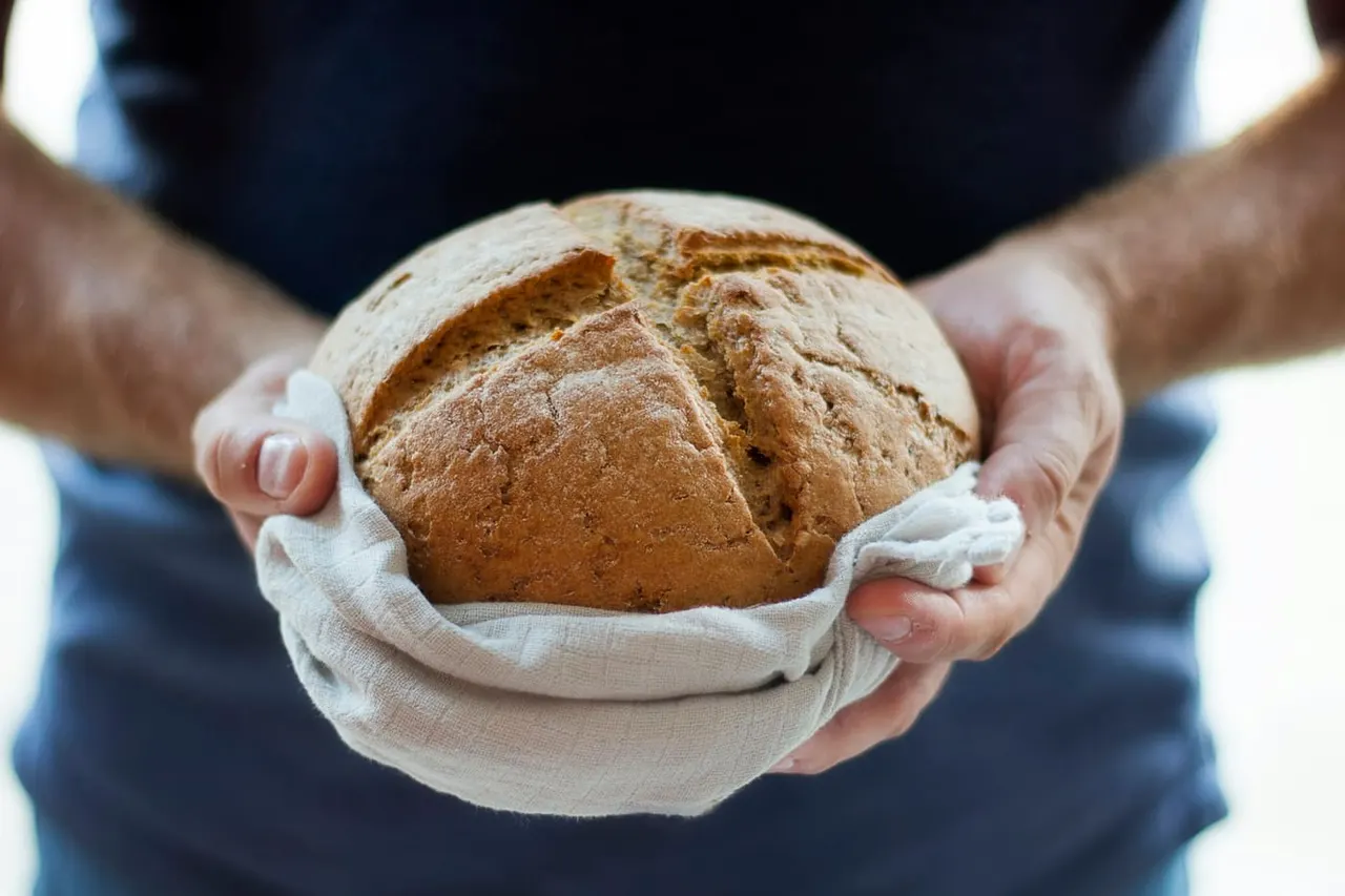 A baker holding a fresh loaf of bread